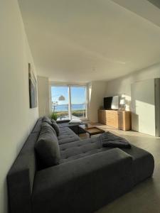 a living room with a couch and a large window at Wohnungen mit direktem Meerblick in Laboe