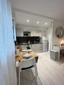 a kitchen with a wooden table and a dining room at Le MACA 1 in Le Cannet