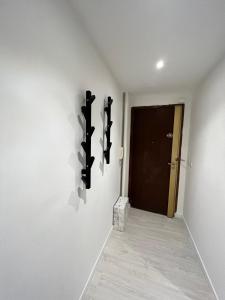 a hallway with a black door and a white wall at Le MACA 1 in Le Cannet