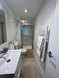 a white bathroom with a sink and a toilet at Le MACA 1 in Le Cannet