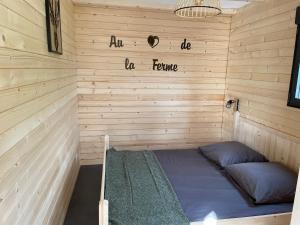 a room with a bed in a wooden wall at Au cœur de la ferme 2 in Lacroix-sur-Meuse