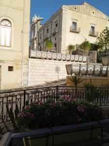 GRETA'S HOUSE في Comitini: مبنى يوجد به سرير ازهار امام مبنى