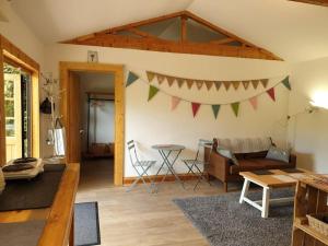 a living room with a couch and a table at The Potting Shed near Tenby, 100" Projector, Four poster bed, On-site HOT TUB access via Spa Pack in Tenby