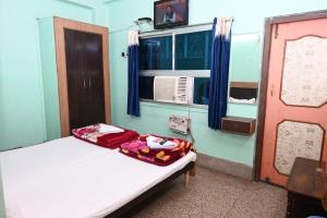 een kleine kamer met een bed en een raam bij Hotel Rajkumar in Patna