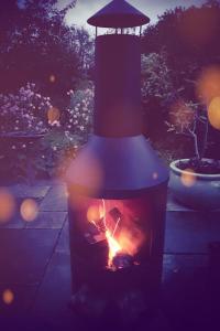 a lantern with a fire in a garden at night at The Potting Shed near Tenby, 100" Projector, Four poster bed, On-site HOT TUB access via Spa Pack in Tenby +19 photos