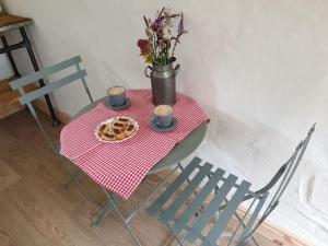 a table with a plate of cookies and a vase with flowers at The Bothy near Tenby, Big Projector Screen, Four-poster bed, on-site HOT TUB access via Spa Pack in Tenby