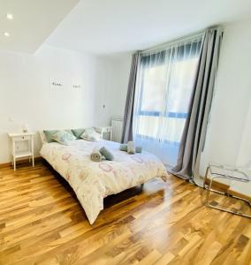 萨拉戈萨Suite Anna的一间卧室，里面有一张床和一扇大窗户。