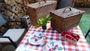 un tavolo da picnic con un piatto di frutta e cesti di CABANE perchée dans les arbres et terrasse ensoleillée a Robion en Luberon