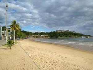 a sandy beach with palm trees and the ocean at Pousada de Ubu in Anchieta