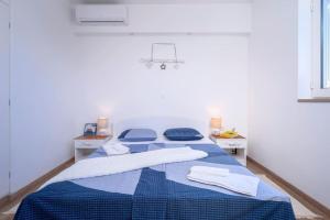 a bedroom with a blue bed with towels on it at AWAKEN Gorgeous Sea View Apartment in Hvar