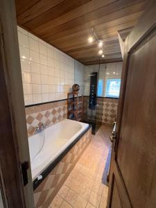 een grote badkamer met een bad in de kamer bij Hoeve Hooierzele in Waasmunster