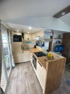 a kitchen with wooden cabinets and a stove top oven at Coeur Des Sables in Saint-Julien-en-Born