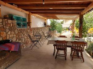 木洛希尼Villa Sommerzauber的一个带桌椅和石墙的庭院