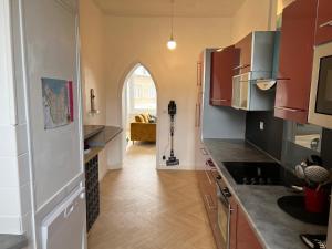 a kitchen with red cabinets and an archway at Appartement hyper centre Perros-Guirec in Perros-Guirec