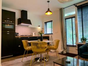 een keuken en een woonkamer met een tafel en stoelen bij Wilde Moeflon, geniet van de vrije natuur! in Otterlo