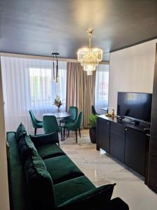 a living room with a green couch and a dining room at Podzamcze No 1 APARTMENT in Wałbrzych