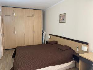 a bedroom with a bed and wooden cabinets at First Line Apartment at Obzor in Obzor +24 photos