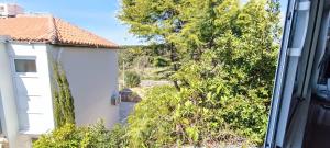 een uitzicht vanuit een raam op een huis en bomen bij Apartment Tena in Novalja