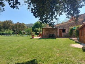 uma casa com um jardim de relva em frente em Can Cabanyes em Llagostera