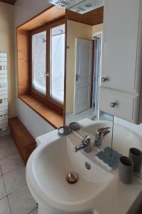 y baño con lavabo blanco y espejo. en Le Chalet de Poche - Gite 2 étoiles - 5 pers en Habère-Poche