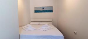 een kleine slaapkamer met een bed met handdoeken erop bij Apartment Tena in Novalja