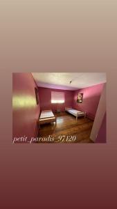 a room with two benches and a pink wall at petit_paradis_97120 in Saint-Claude