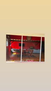 a room with a table and a red wall at petit_paradis_97120 in Saint-Claude