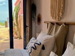 um quarto com uma cama com almofadas e uma porta de vidro deslizante em Casa Playa em Denia