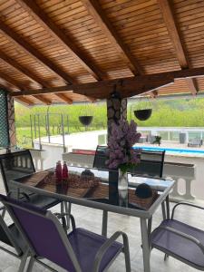 a dining table and chairs under a wooden ceiling at Villa Enio in Bihać