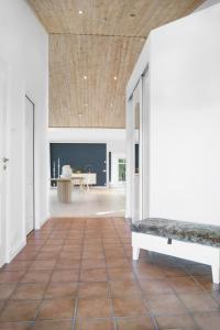 an open living room with a wooden ceiling and a bench at Luxury three-bedroom modern family home in Båstad in Båstad