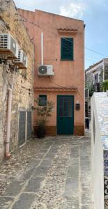 a building with a green door on a street at Casetta Milu’ in Ustica