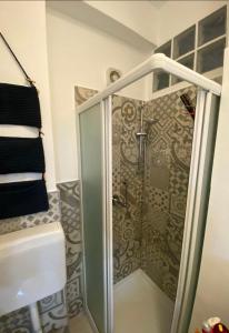 una doccia con porta in vetro in bagno di Casetta Milu’ a Ustica