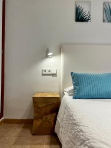 a bedroom with a bed and a blue pillow at Casa Coromines in Alcudia