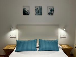 a bedroom with a bed with two blue pillows at Casa Coromines in Alcudia