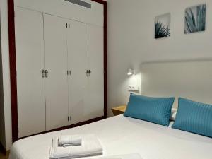 a bedroom with a large white bed with blue pillows at Casa Coromines in Alcudia
