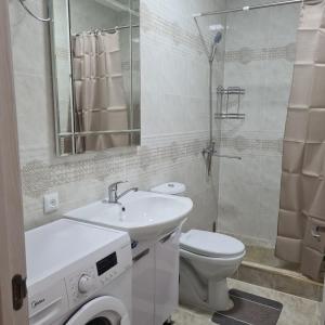 ein Bad mit einem Waschbecken, einem WC und einer Dusche in der Unterkunft Иссык-Куль Кыргызстан, коттедж ЦО Палм Бич in Chok-Tal