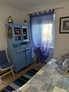 a bedroom with a blue cabinet and a window at Apartments Luna in Baška