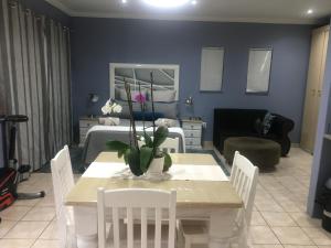 a living room with a table and a room with a bedroom at Rest Assured in Roodepoort