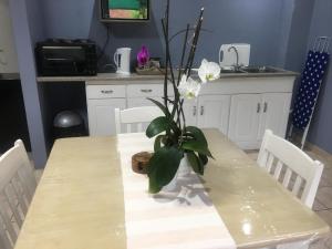 una mesa con un jarrón con flores blancas. en Rest Assured en Roodepoort