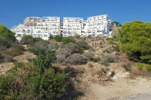 een groot wit gebouw bovenop een heuvel bij Piso en la primera linea del mar con 2 dormitorios in Benidorm