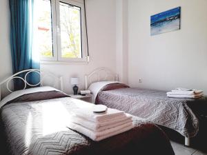 1 dormitorio con 2 camas y toallas. en Kallithea Central Residence, en Kallithea Halkidikis