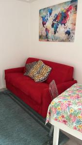 a red couch in a living room with a table at Franz home Wi-Fi AC 1 free parking in Bolzano