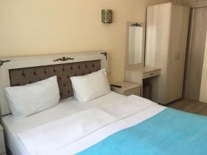 1 dormitorio con 1 cama blanca grande y 2 almohadas en Amida House, en Estambul