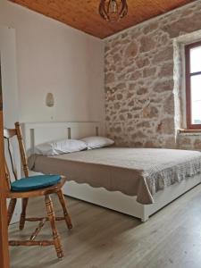 sypialnia z łóżkiem i krzesłem w obiekcie Apartman Blaslov Kali w mieście Kali