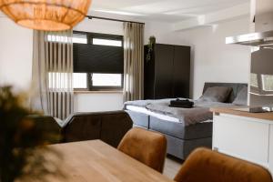 Habitación pequeña con cama y sofá en De la Rue Vakantiesuites, en Sleeuwijk