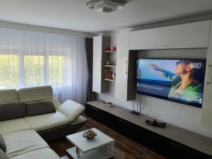 a living room with a couch and a flat screen tv at Seaside Home Apartment in Mangalia