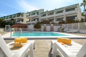a resort with a swimming pool and a building at Delightful front beach apartment. Sunrise views! in Playa del Aguila
