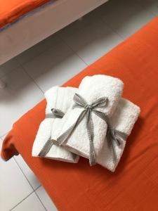 a pile of white towels with a bow on a bed at White Suite Rooms in Kucukkoy