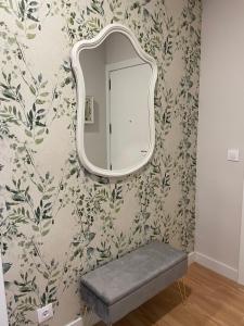 un espejo en una pared con un banco en una habitación en Apartamento Cuatro Estaciones, en Calahorra