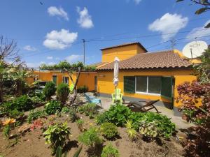 リベイラ・グランデにあるCasa Amarela de Santanaの黄色い家の前の庭